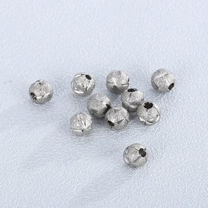 Close-up of frosted and engraved silver stainless steel beads with small center holes