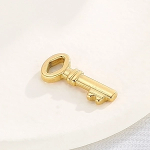 Detailed view of a minimalist gold stainless steel key pendant for DIY jewelry making
