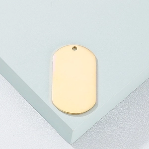 Close-up of polished gold military style stainless steel dog tag on a blue pedestal