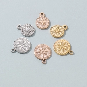 Detailed view of textured round metal charms with starburst pattern in gold and silver