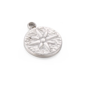 Macro shot of silver stainless steel star embossed pendant with detailed engraving