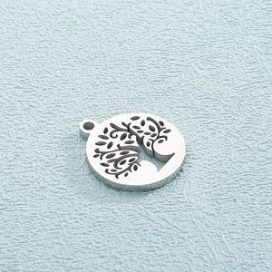 Detailed view of silver titanium steel circular pendant featuring a hollow Tree of Life design