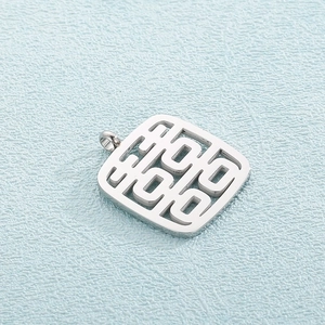 Close-up of silver hollowed square Xi symbol pendant with polished finish on blue background