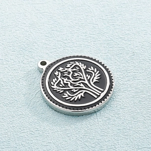Macro shot of silver titanium steel tree of life pendant with beaded edge detail