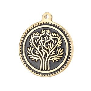 Macro shot of gold-plated tree of life pendant with black enamel inlay and dotted edges