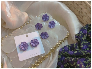 Detailed macro view of purple gardenia flower earrings with delicate layered resin petals