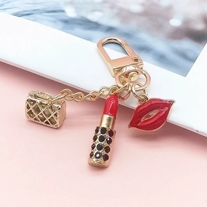 Golden keychain with mini quilted handbag, red lip and rhinestone lipstick pendants