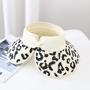 Close-up of leopard print pattern and bow detail on an open-top straw sun hat