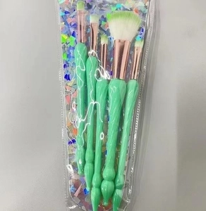 Detailed view of 5 mint green shell makeup brushes with rose gold ferrules in packaging