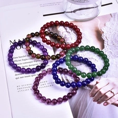 Top-down macro view of colorful crystal beaded bracelets in red, blue and purple