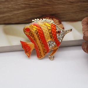 Detailed macro shot of tropical fish brooch with orange enamel and sparkling crystals