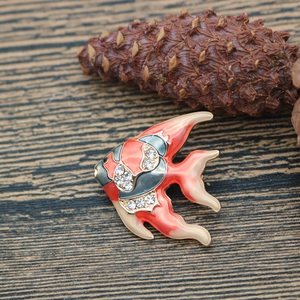 Macro detail of a koi fish brooch with orange enamel and sparkling rhinestones