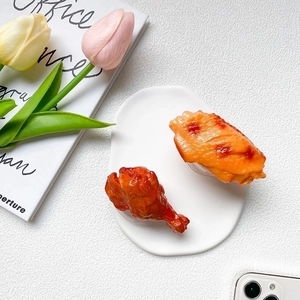 Realistic roasted chicken leg and wing shaped retractable phone socket on a white plate