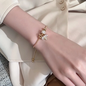 Golden snake chain bracelet featuring zircon beads and a delicate bee charm on wrist