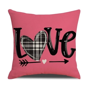 Detail of pink linen pillowcase featuring black LOVE lettering and checkered heart pattern