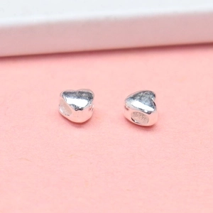 Polished S925 sterling silver heart beads for jewelry making on pink background