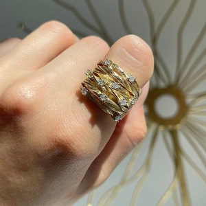 Close-up of golden vine ring with sparkling zircon stones on a female finger