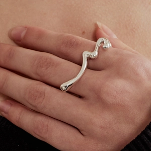 Close-up of a 925 sterling silver ring with an irregular liquid wave texture on a finger