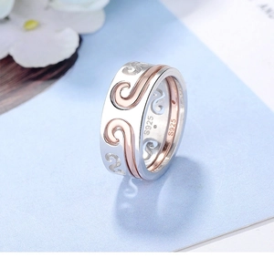Close-up of S925 engraved two-tone silver and rose gold rings with swirl texture
