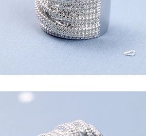 Close-up of wide silver wave ring featuring multi-row braided micro-paved cubic zirconia
