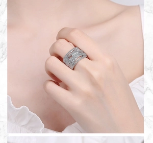Close-up of wide silver multi-row wave ring with pavé cubic zirconia on model finger