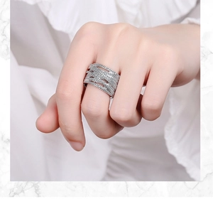 Detail of wide silver wavy ring with small cubic zirconia stones on model finger