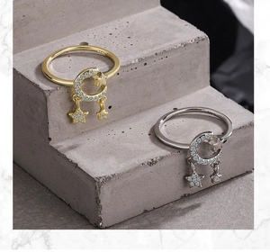 Detailed view of S925 silver star and moon rings with dangling star pendants and zircon