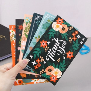 Detail of hand holding assorted floral thank you cards with vibrant nature patterns