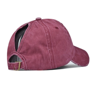 Detail view of burgundy washed cotton ponytail baseball cap with distressed brim and V-opening