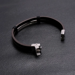 Dettaglio del bracciale in pelle marrone a doppio strato con chiusura in acciaio