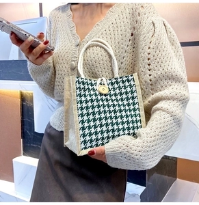 Detail of woven linen handbag featuring green houndstooth pattern and wooden button closure