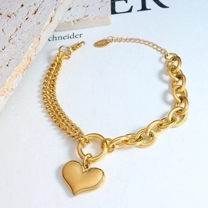 18K gold plated Cuban link chain heart bracelet for women on white marble background