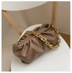 Detailed view of a brown cloud handbag with a stylish chunky gold chain strap on a chair