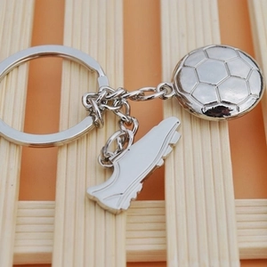 Detail of silver metal soccer ball and cleat shoe pendants on a round keychain