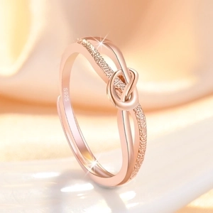 Elegant rose gold knot ring with frosted texture and S925 engraving on a warm fabric