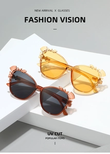 Detailed view of floral crystal accents on UV-cut fashion sunglasses on display stands