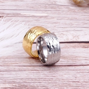 Detailed view of gold and silver stainless steel rings with irregular hammered textures