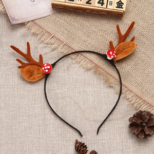 Detail shot of Christmas reindeer antler headband with mushroom accents on linen background