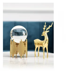 Detail of luxury crystal ball on gold metal stand with a matching golden deer sculpture