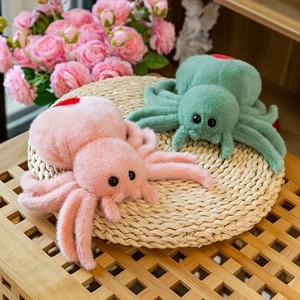 Detailed close-up of colorful plush spider toys with red heart patterns on woven mat
