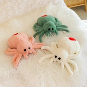 Detailed view of colorful plush toy spiders with red hearts on soft white rug