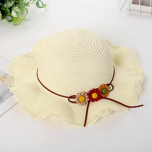 Detail of kids straw sun hat featuring wavy brim and colorful floral ornaments