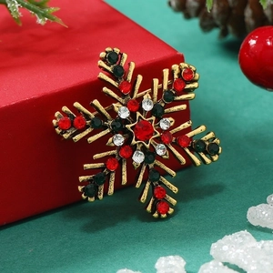Christmas snowflake brooch with colorful crystals on a red gift box festive backdrop