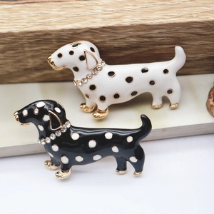 Detail of enamel dachshund brooches with rhinestones in black and white spotted patterns
