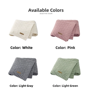 Detail of four colored knitted baby blankets with waffle weave and leather brand tags