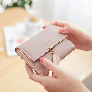 Detailed view of pink vintage wax leather wallet with leaf pendant and snap closure