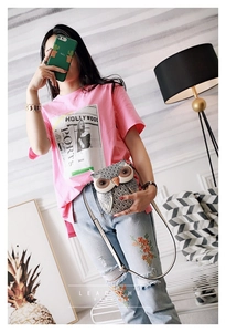Close-up of stylish owl shaped crossbody bag with floral embroidered ripped jeans