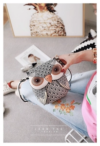 Close-up of owl-shaped shoulder bag with feather patterns and orange beak accents