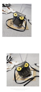 Detail view of owl-shaped crossbody bag with gold feather print and large yellow eyes