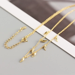 Close-up of gold S925 sterling silver necklace with chili horn pendants and lobster clasp